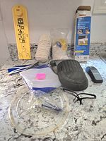 Overview of lot contents including air conditioner support, knee pad, rope, tubing, staple remover, and other tools.