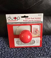 Front view of DUOP small pad holder packaging with red spherical holder and white microfiber pad.