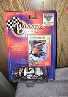 New Winners Circle Dale Earnhardt Sr. die cast car in original sealed packaging. Packaging includes a collectible card depicting Dale Earnhardt Sr.