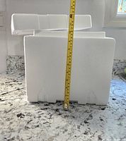 Styrofoam cooler measured approximately 11 inches in height next to measuring tape.