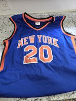 Blue New York Knicks basketball jersey with orange and black trim, front with 'NEW YORK 20'