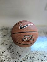Front view of Nike All Court 1000 basketball showing the Nike swoosh logo and textured surface.