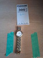 Watch laid flat with maxsold lot card