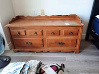 Front view of wooden blanket box showing four faux drawers and brass-tone pulls