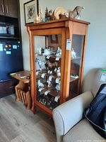 Front view of wood cabinet with glass door and shelves