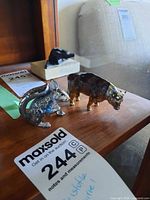 Christofle squirrel and Peltro bull figurines on wood shelf with MaxSold tag