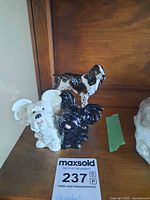 All three dog figurines displayed together on shelf