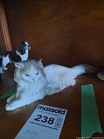 Full view of Nao porcelain reclining cat figurine on shelf