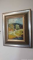 Front view of framed landscape painting on wall