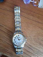 Full view of two-tone Victorinox Swiss Army watch on wooden surface