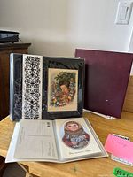 Two binders displayed; cards visible in sleeves, including portrait postcard