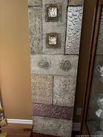 Full view of large framed abstract canvas showing geometric textures and mixed metallic tones.