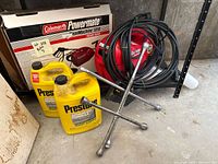 Full lot showing Coleman Powermate 1210 pressure tire inflator, three tire wrenches, and two antifreeze containers.