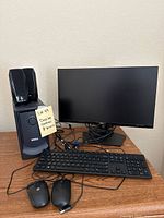 Dell desktop speakers stacked on the subwoofer with Dell monitor and keyboard on desk with two wired mice in front.