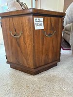 Close-up side view showing wood finish, brass handles, and doors.