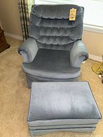 Full view of heathered blue rocket glider rocking chair with matching footstool on carpeted floor near window