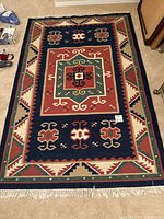 Full view of the large rectangular area rug laid flat on floor, showing entire design and colors.
