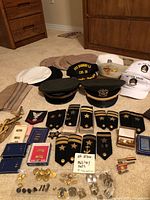 Overview of hats and insignia laid out on carpet