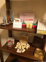 Shelves showing miniature figurines, cigar boxes, candles and a framed poem