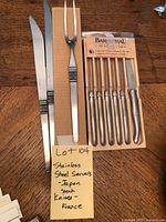 Photo showing two 14-inch serving knives, one 11-inch serving fork with detailed Eterna pattern handles, and the Barenthal steak knife set boxed.