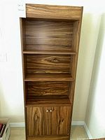 Front view of the wood bookshelf showing three open shelves and two doors at the bottom.