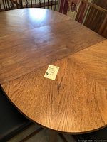 Close-up of wood dining table surface showing wood grain and a note identifying the lot as 'Wood Dining Table Set'.