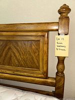 Close-up of upper corner showing wood grain detail, turned post, and part of the metal frame.