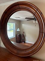 front view of round mirror with wood frame
