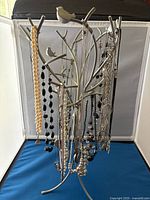 Front view of metal jewelry stand with all necklaces displayed
