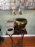 All six items grouped: brass planter, square ceramic planter, round ceramic planter, two glass terrariums hanging, metal holder