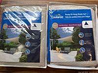 Two sealed Coolaroo shade sail packages front view