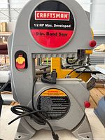 Front view showing Craftsman badge, 9-in band saw label, power switch, table and fence