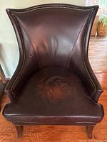 Front view of leather accent chair showing upholstery and nailhead trim