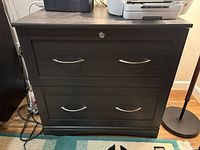 Front view showing two drawers with metal handles and lock