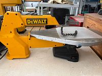 Left side view of DeWalt DW788 scroll saw showing overall form, table, arm and base