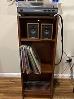 Full view of stand with turntable on top, speakers in shelf, records stored, showing overall lot