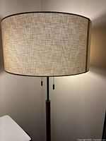 Upper portion showing beige drum shade, pull chains visible