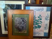 Three of four framed art prints showing wood frames and artwork