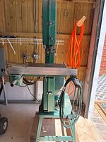 Front view of Grizzly G1073 bandsaw on stand showing table, fence bar and overall condition