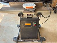 Front view of Jet jointer on mobility base showing tables, cabinet, power switch