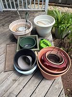 Group view of nested plastic pots, hanging planters, square planter, watering can and tray