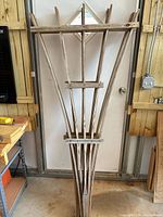 Stack of three wooden trellises leaning against wall showing overall structure