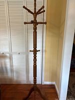 Full view of coat rack showing overall design and tripod base