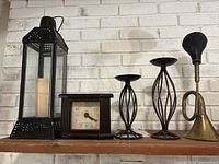 Full lot view showing lantern, clock, two candlesticks, brass bugle