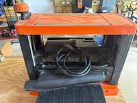 Front view showing cutterhead housing, cord, and fold-down table