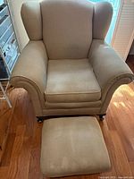 Front view of upholstered wingback chair and ottoman