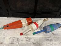 All three wooden buoys showing paint colors and rope loops