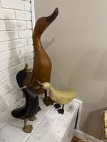 Front view of three duck figurines showing relative sizes and colors