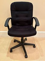 Front view of black padded office task chair showing full structure