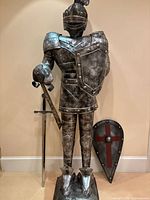 Front view of full-size knight armor with sword, attached shield, and separate kite shield